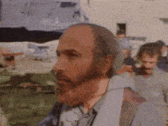 a man with a beard is standing in a crowd