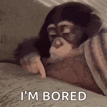 a chimpanzee is laying on a couch and pointing at something .