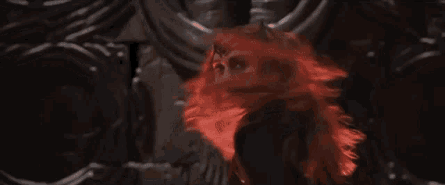 a woman with red hair is standing in a dark room with a skeleton in the background .