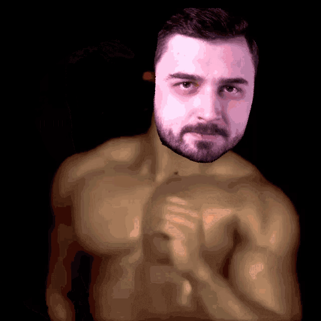 a shirtless man with a beard looks at the camera with his hand on his chest