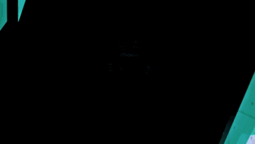 a man in a petronas uniform is standing in a dark room