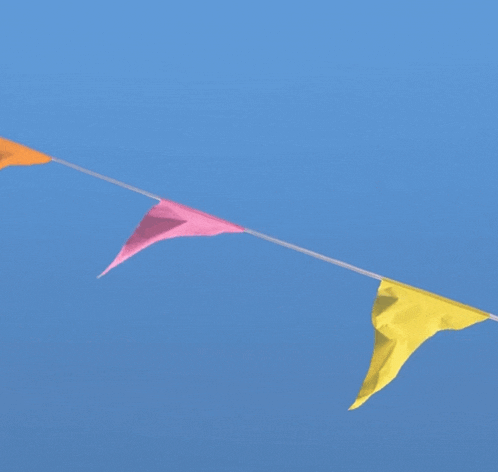 pink and yellow flags are flying in the blue sky