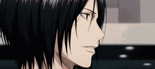 a close up of a person 's face with long black hair and a serious look on his face .
