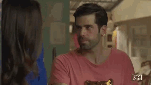 a woman is giving a man a thumbs up in the kitchen .