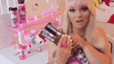 a woman is holding a gun in her hands in front of a pink hello kitty desk .
