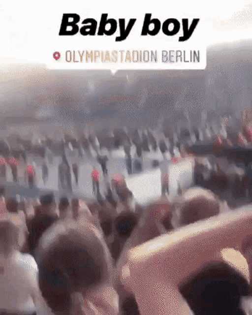 a crowd of people in a stadium with the words baby boy olympiastadion berlin above them