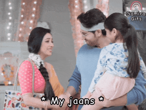 a man and woman holding a child with the caption " my jaans " on the bottom