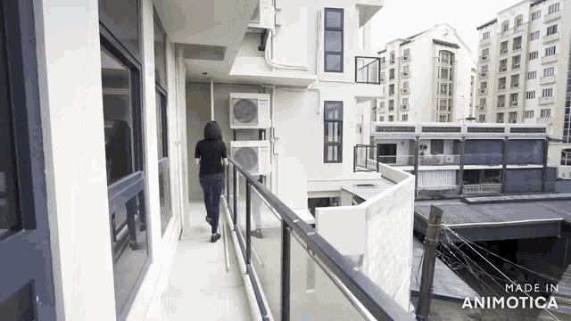 a woman walking down a balcony with the words made in animotica on the bottom right