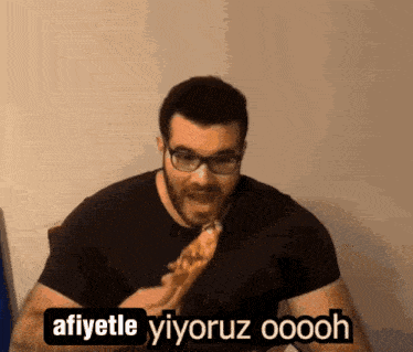 a man with glasses is eating a piece of pizza and says " afiyetle yiyoruz ooooh "