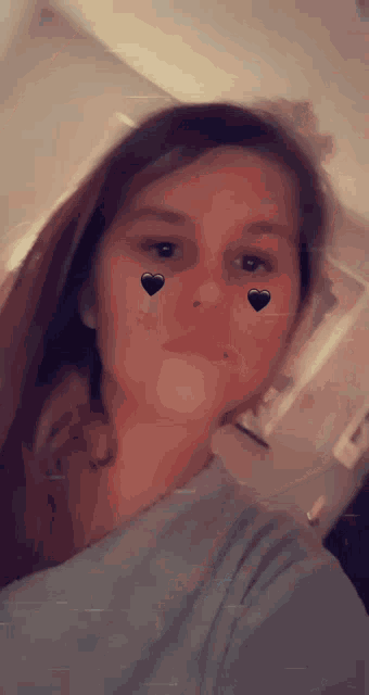 a woman with hearts on her face takes a selfie