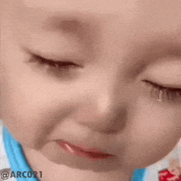 a close up of a baby 's face with tears running down his face .