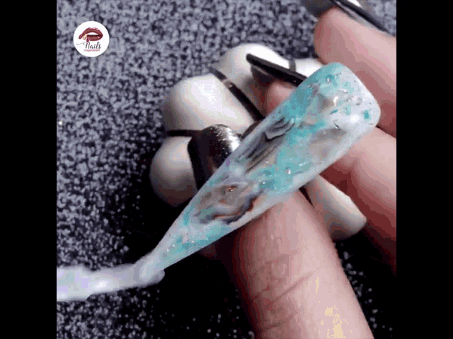 a close up of a person 's nails being painted with blue and white nail polish