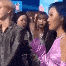 a group of women are standing next to each other in a crowd at a party .