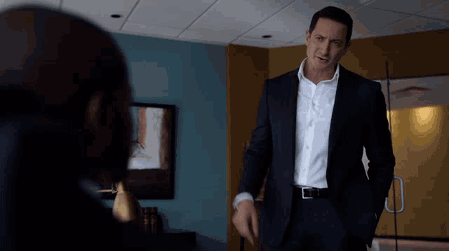a man in a suit with his hands in his pockets