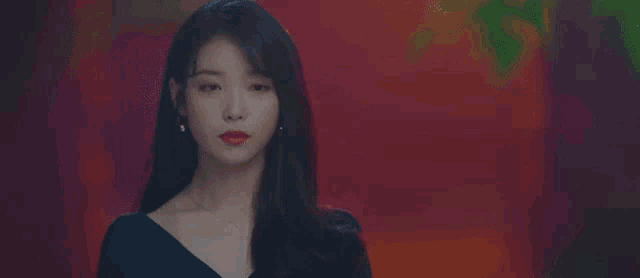 a close up of a woman wearing red lipstick and earrings .