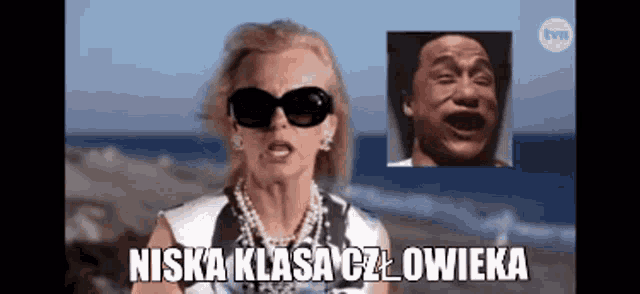a woman wearing sunglasses and a pearl necklace stands in front of a picture of a man with his mouth open