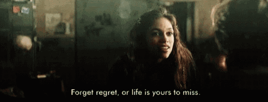 a woman is talking to a man in a dark room and says `` forget regret , or life is yours to miss ''