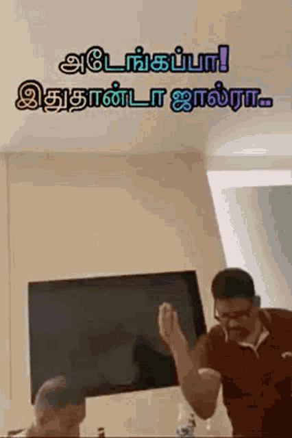 a man is standing in front of a television in a living room with his hands in the air .