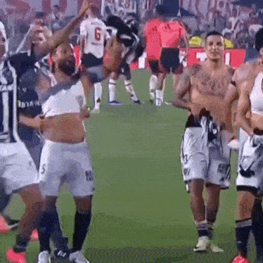 a group of soccer players are celebrating on a field