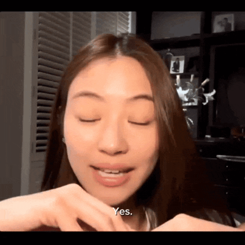 a close up of a woman 's face with her eyes closed and the words yes on the bottom .