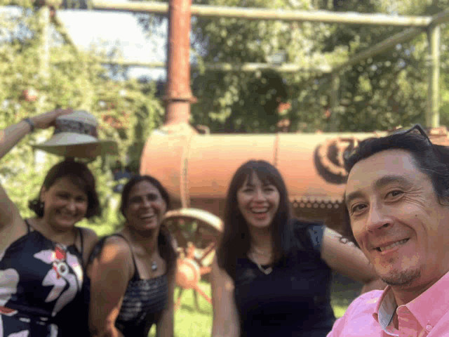 a man in a pink shirt holds a hat in front of three women