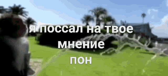 a blurry picture of a house and trees with russian writing in the foreground
