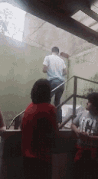 a man in a white shirt is walking up stairs