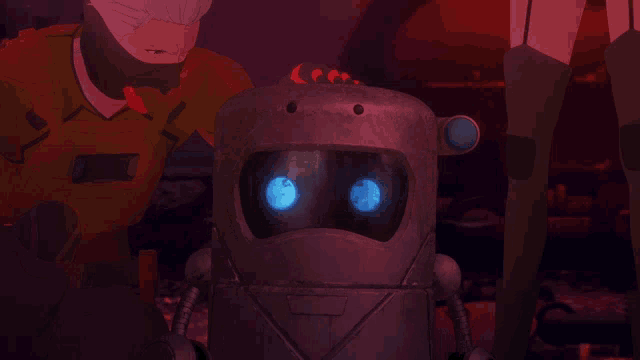 a robot with blue eyes is surrounded by a man and a woman