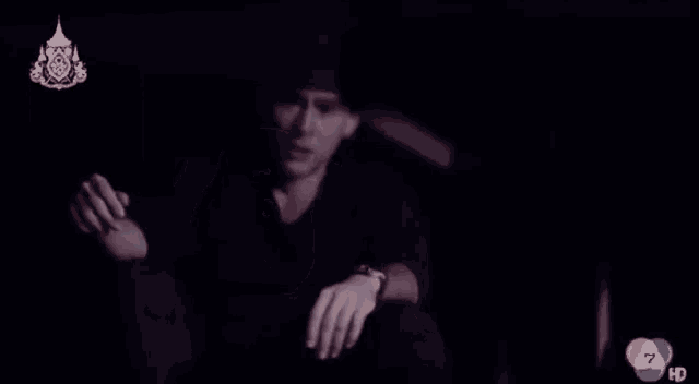 a man is sitting in the dark with the number 7 on the bottom right