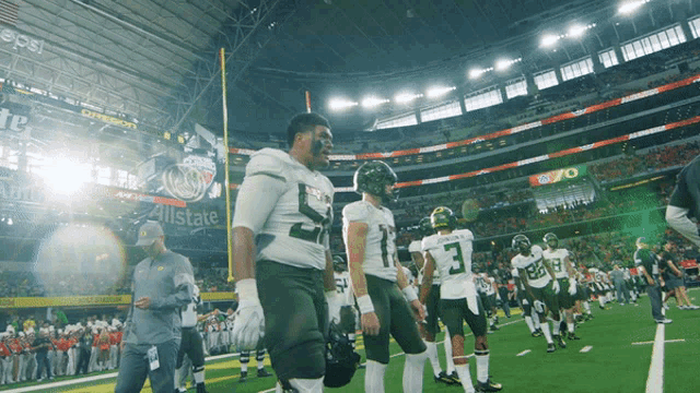 a group of football players standing on a field in front of a pepsi ad