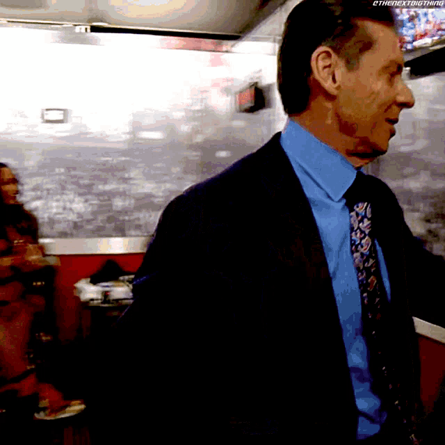 a man in a suit and tie is standing in front of a sign that says ethenextbig thing