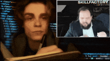 a man in a suit is talking to another man in front of a skillfactory screen