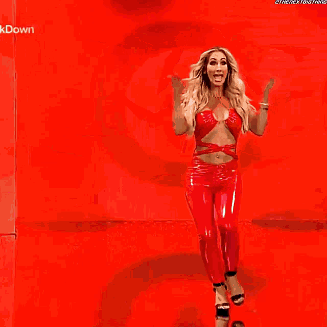 a woman in a red top and pants is standing on a stage with the words " kdown " written on the bottom
