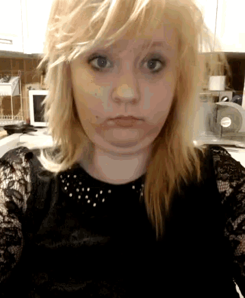 a woman with blonde hair is wearing a black lace shirt