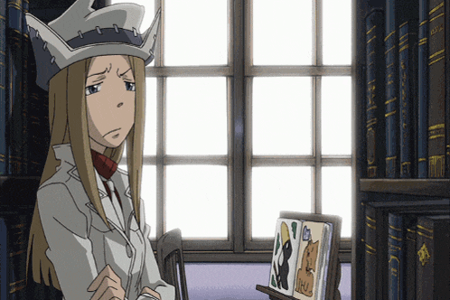 a woman sitting in front of a bookshelf with a picture of a cat on a stand