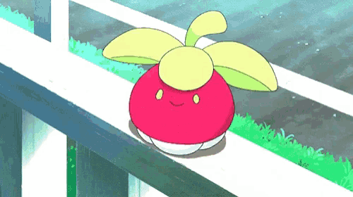 a red and yellow cartoon character is sitting on a ledge