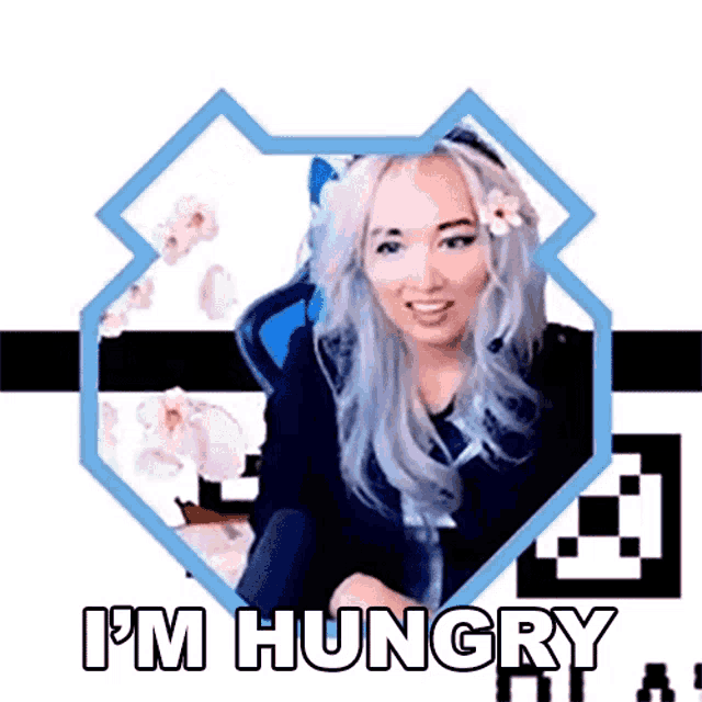 a woman with a flower in her hair is sitting in a chair and smiling . she is hungry .