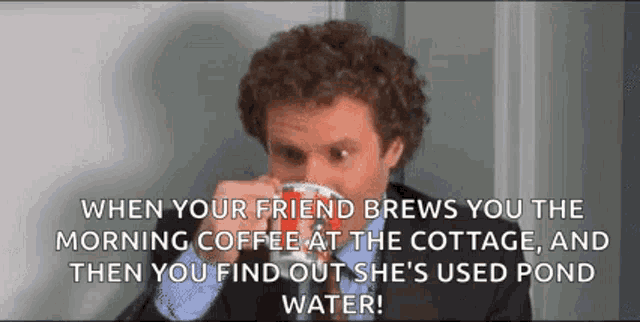 a man in a suit is drinking a cup of coffee at the cottage .