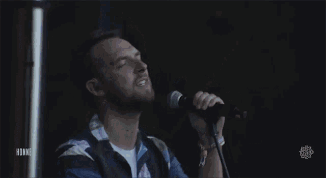 a man singing into a microphone with the word honne on the bottom left