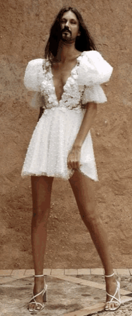 a woman wearing a white dress with a plunging neckline