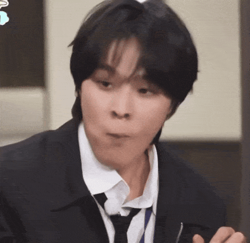 a man in a suit and tie is holding a fork and making a funny face .