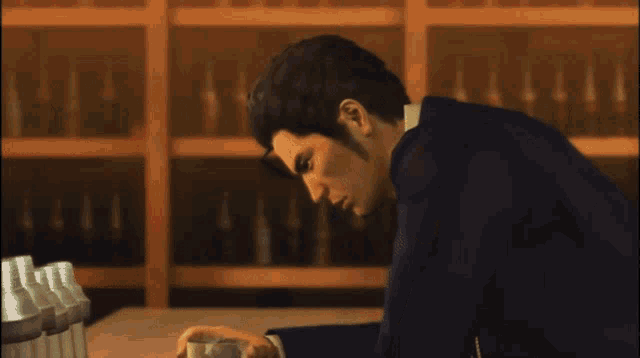 a man in a suit is drinking from a glass in a bar