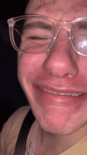 a close up of a man wearing glasses and smiling