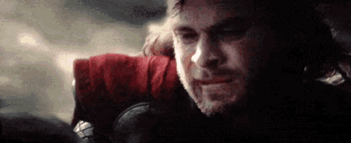 a close up of a man 's face with a beard and a red scarf around his neck .