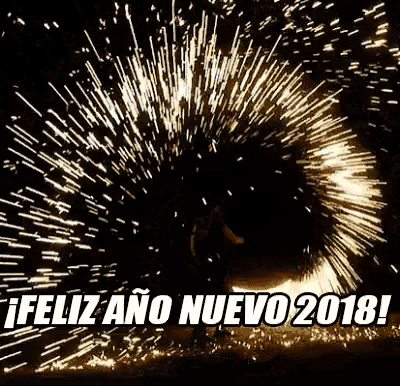 a man is standing in front of a fireworks display with the words `` feliz ano nuevo 2018 '' written on it .
