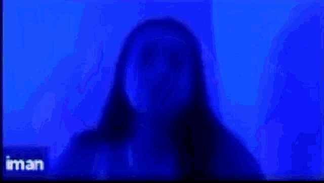 a woman is giving the middle finger in front of a blue background ..