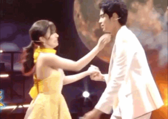 a man and a woman are dancing on a stage .