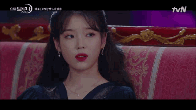 a woman with red lipstick is sitting on a couch with the tvn logo in the corner
