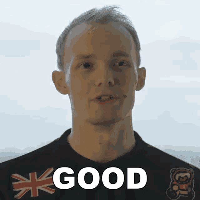 a man wearing a black shirt with the word good written on it