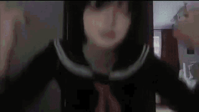 a girl in a school uniform is standing in front of a door and looking at the camera .
